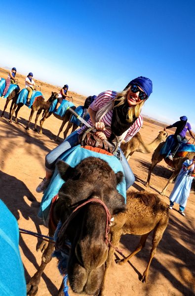 Blonde girl riding camel in desert - 48 Hours in Marrakesh Guide 