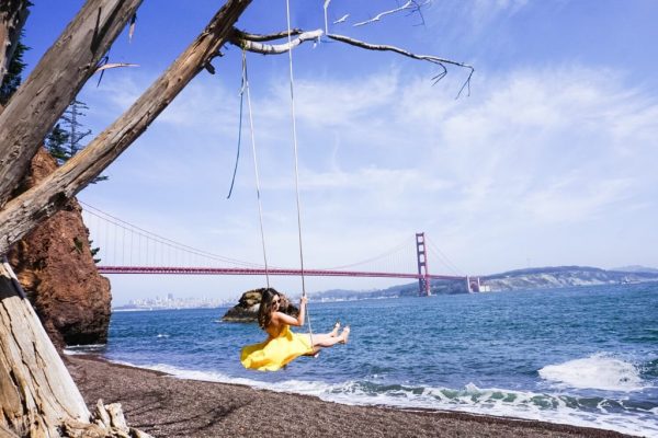 Meet Clumsy Traveler Christine; girl swinging in yellow dress San Francisco