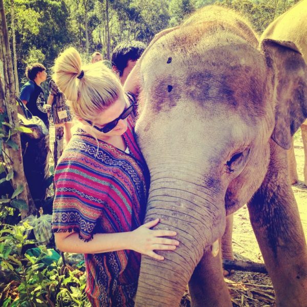 Meet Clumsy Traveler Chloe; blonde girl playing with elephant