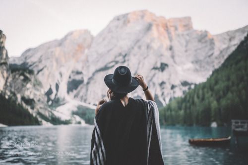 Travel When You Have a Bad Back; girl facing mountains and blue lake blake hat travel wanderlust