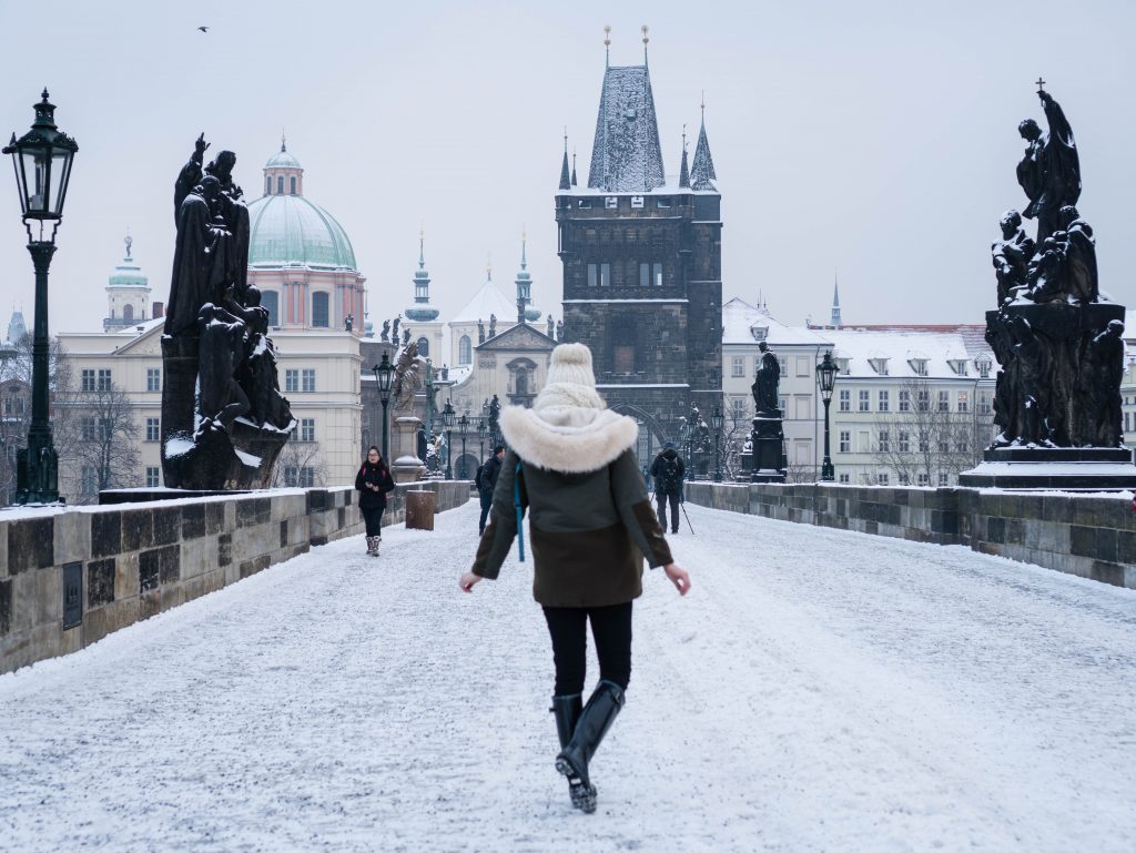 Winter Wonderland Lookbook; blonde girl on Charles Bridge Prague chunky knit scarf and beanie snow