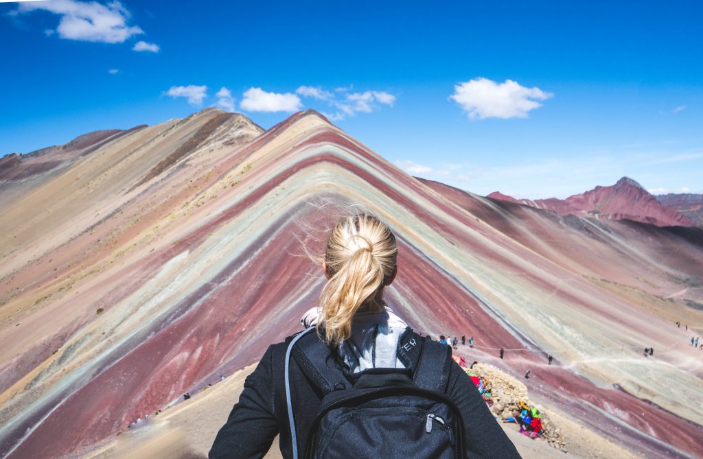 traveling with HYLETE; girl hiking rainbow mountain in Peru