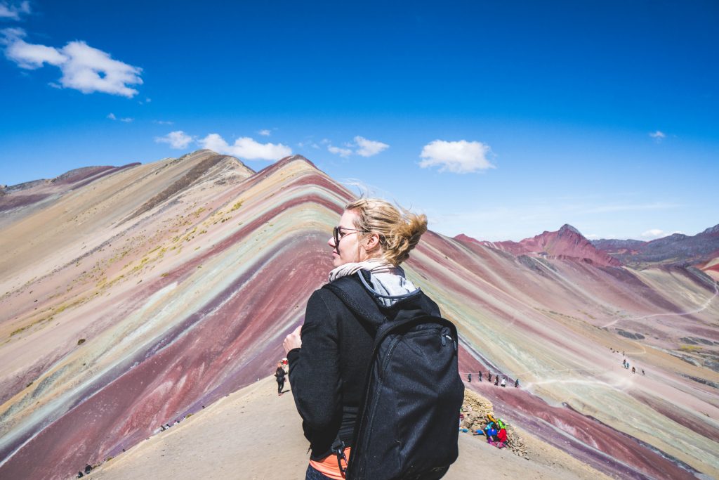 traveling with HYLETE; girl hiking rainbow mountain in Peru