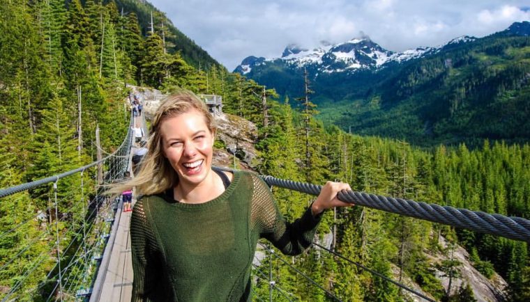 travel and reduce your carbon footprint; girl on suspension bridge canada