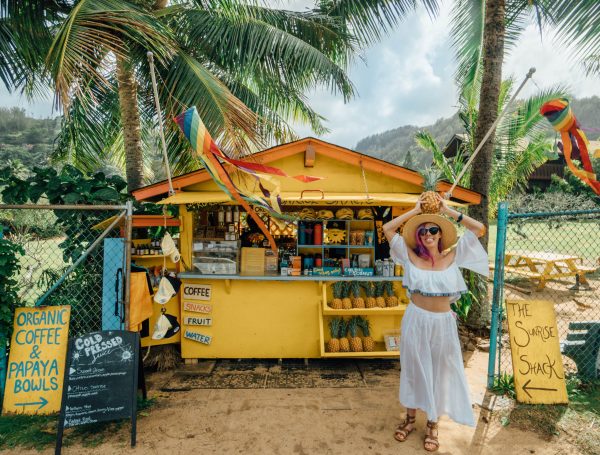 best things to do in Oahu; girl with pineapple at the Sunrise Shack yellow north shore