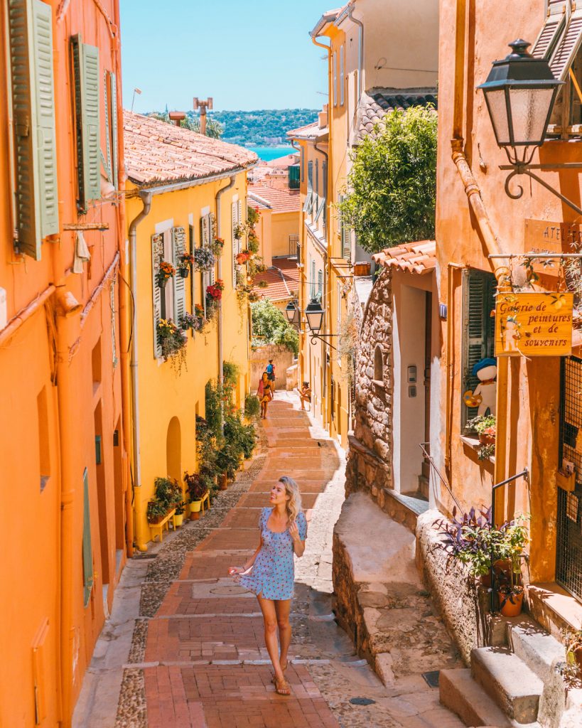 The Perfect 7-14 Day Provence and Côte d'Azur Itinerary; girl walking in blue dress in alleyways of Menton